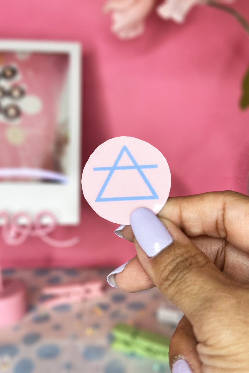 Pastel Pink Background with Baby Blue Image Glossy Air Element Sign Sticker Held Up Focused Close Up