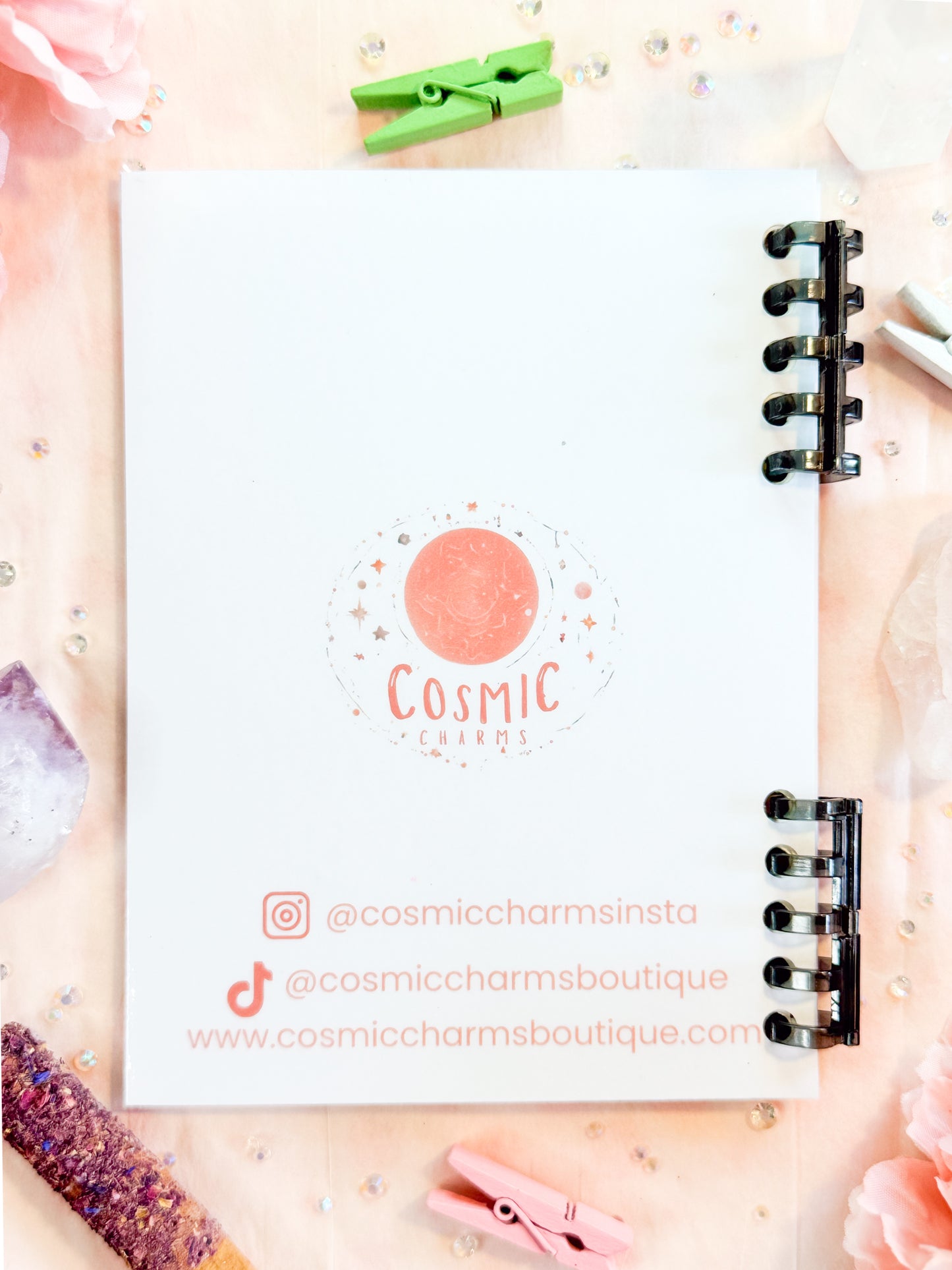 Back cover of Cosmic Charms sketchbook with brand logo and social media handles.